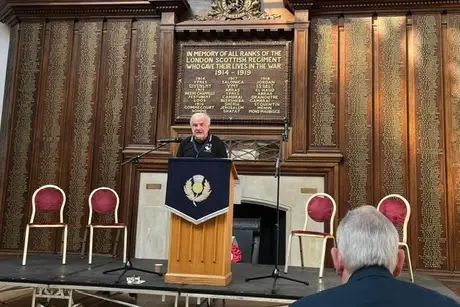 Edmund O’Sullivan standing on a platform speaking to an audience.