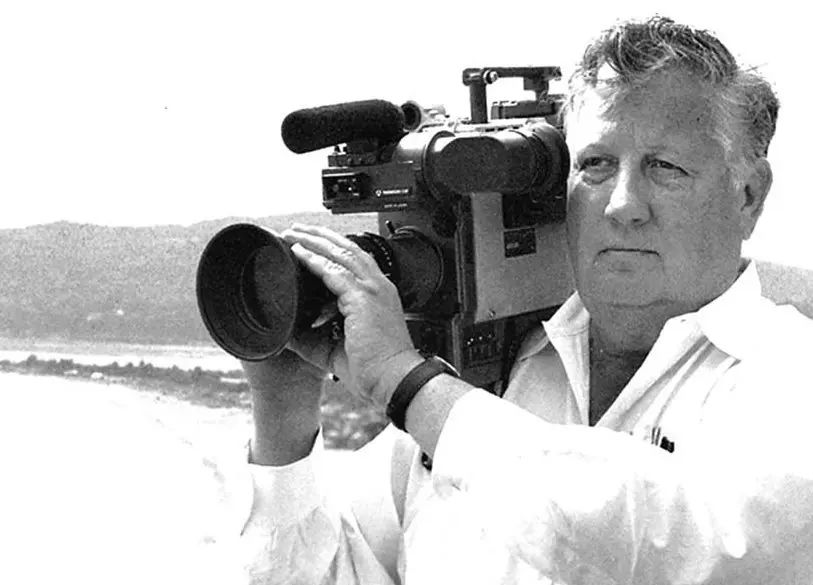 Robert Drew in black and white holding an old video camera